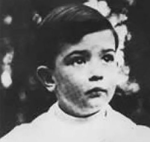 A young boy in white shirt and black pants.